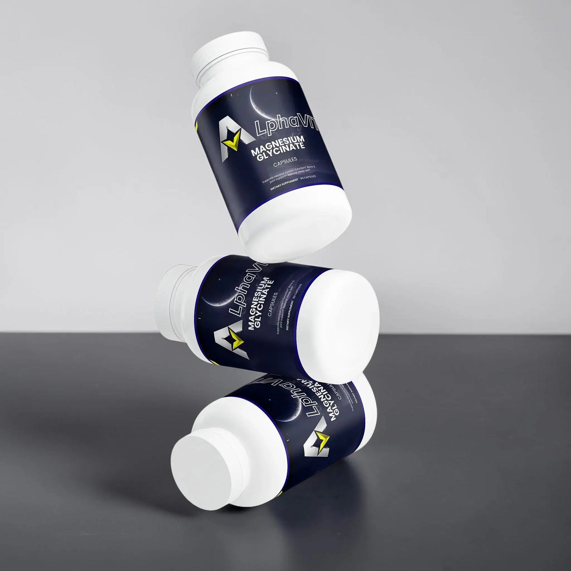 Trois flacons de capsules de magnésium glycinate AlphaVIT flottant sur fond blanc pour le soutien du sommeil.