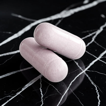 Deux capsules AlphaVIT pour la santé oculaire de couleur mauve pâle sur fond blanc.