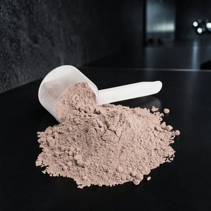 Poudre de protéine AlphaVIT Whey Isolate au chocolat avec mesurette en plastique sur fond blanc